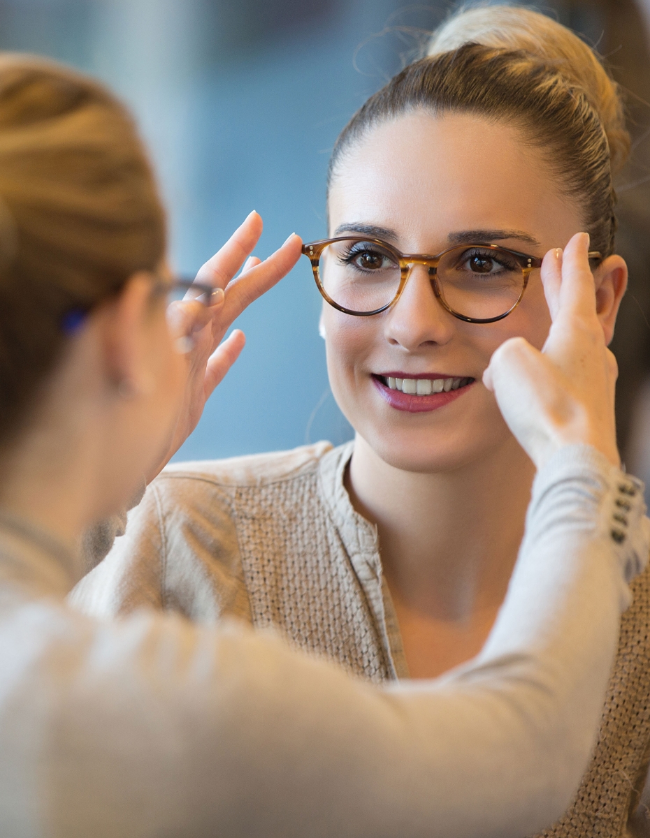 Frau bei der Anpassung der Brille einer Kundin. 