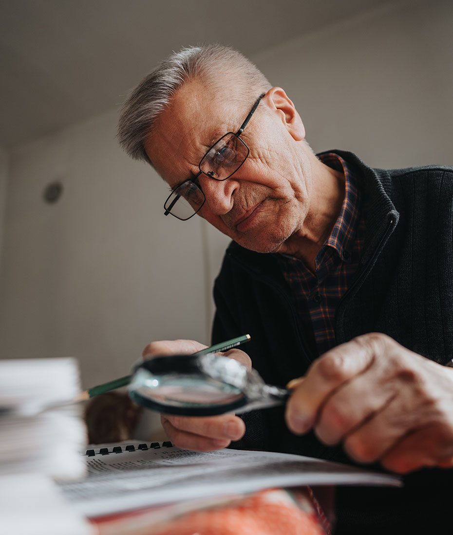 Mann mit Brille hält Lupe