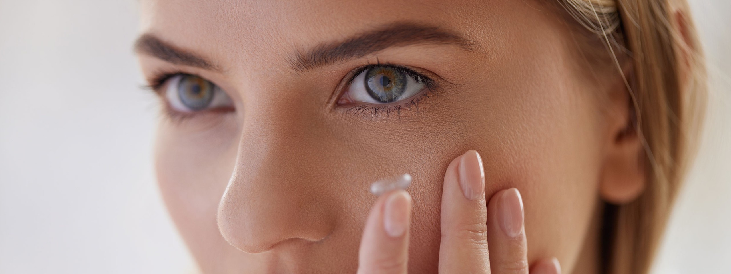 Frau setzt Kontaktlinse auf